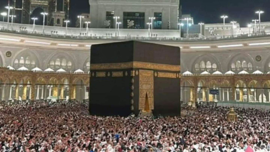 "Crowds of Umrah pilgrims at the Grand Mosque in Mecca during Ramadan, with security personnel managing movement and digital signals guiding entry."